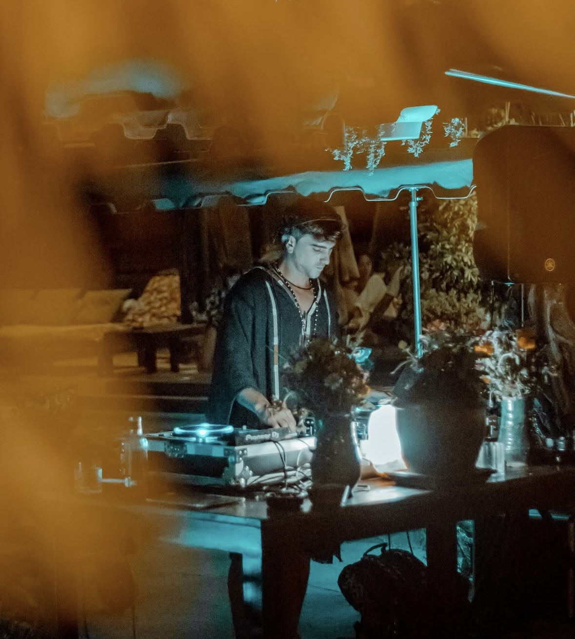 ORIAM performing behind the decks in warm candlelight